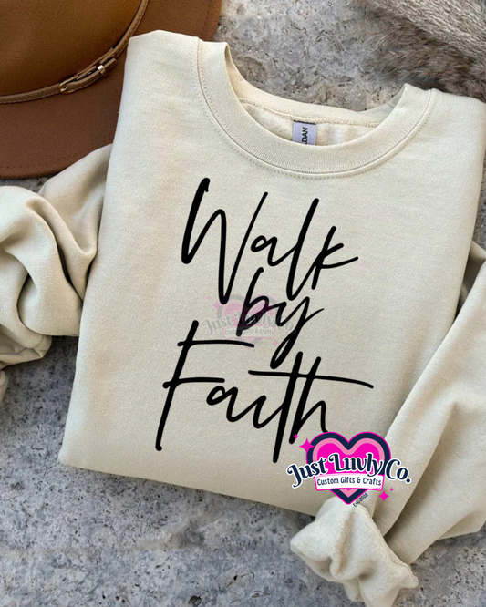 Beige sweatshirt with 'Walk by Faith' text on a textured surface, featuring Just Luvly Co. branding.